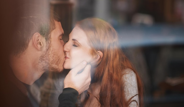L'amour dans un café Un jeune couple partage un baiser lors d'un rendez-vous