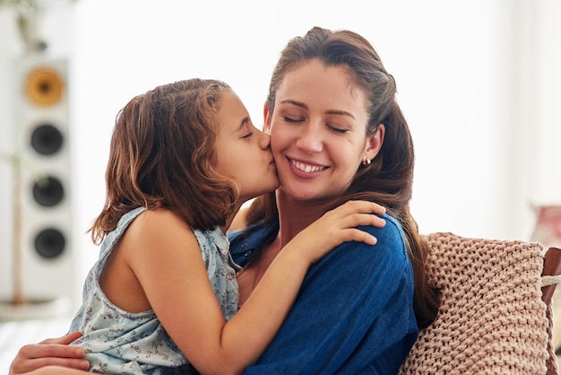 L'amour est beau à exprimer mais encore mieux à ressentir Photo recadrée d'une jeune fille embrassant sa mère à la maison