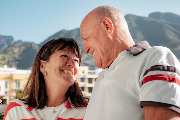 L'amour est toujours doux entre un couple de personnes âgées amoureux debout en plein air se regardant dans les yeux