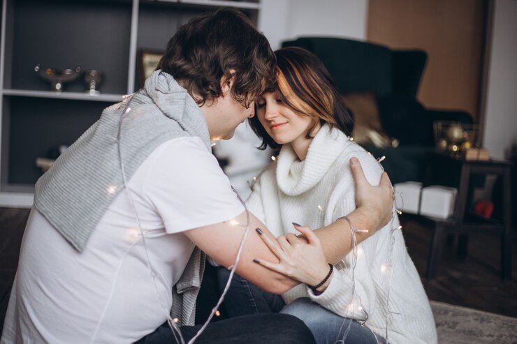 Photo amour jeune couple étreignant sur l'arbre de noël