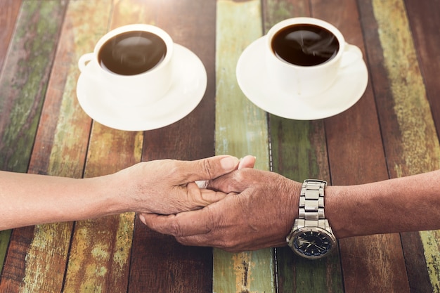 Photo amour de la main de couple ole dans un café