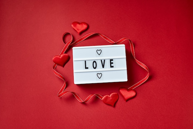 Amour message lightbox avec des coeurs rouges. Flatlay vue de dessus.