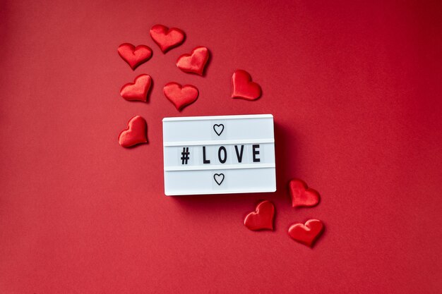 Amour message lightbox avec des coeurs rouges. Flatlay vue de dessus.