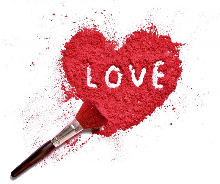 Photo amour sur la poudre de couleur de maquillage écrasé en forme de coeur avec un pinceau