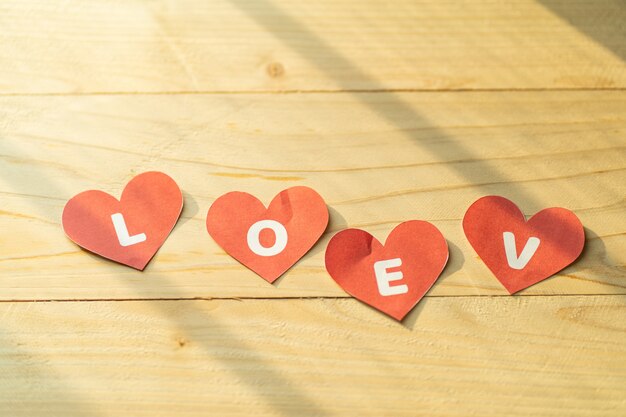 Amour quatre coeur rouge sur plancher en bois