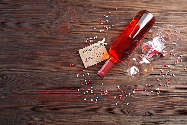 Un amour, une vie concept - bouteille de vin et verres avec des coeurs autour
