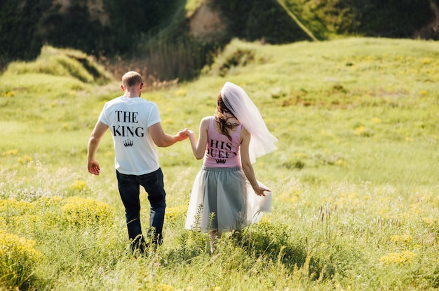 Les amoureux courent avec la main sur le parc de la ville