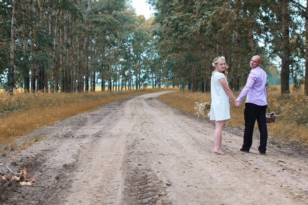 Photo amoureux juste mariés marchant dans un champ en automne