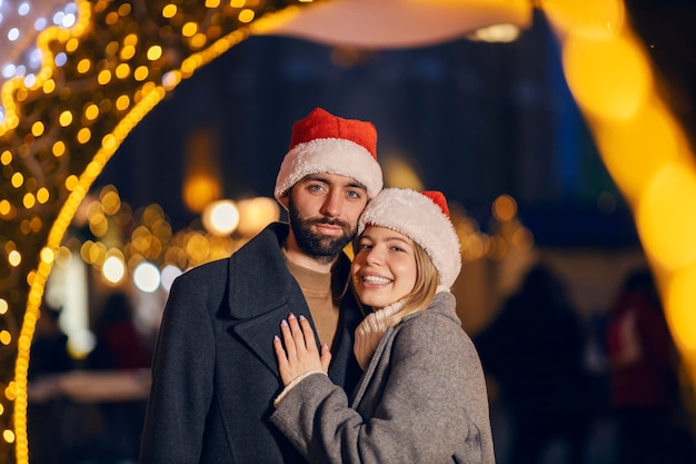 Amoureux de Noël souriant dans la rue le soir du Nouvel An