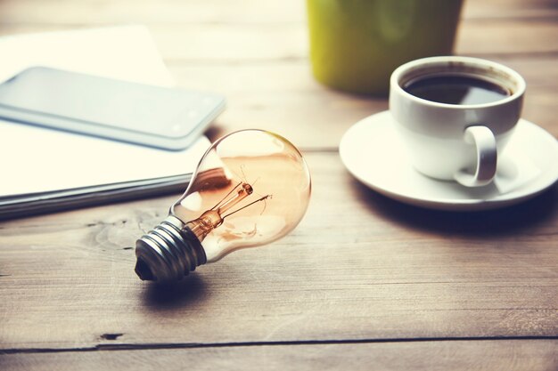 Ampoule, café, téléphone sur table