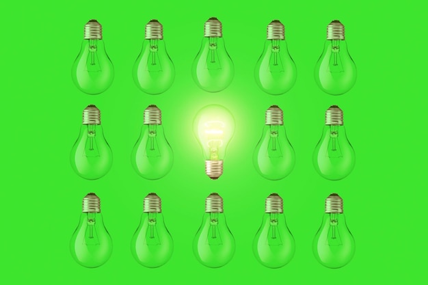 Une ampoule créative se trouve et brille parmi les ampoules éteintes sur une vue de dessus de fond vert Énergie verte un concept Pensez à une idée créative différente Pensée créative intelligente