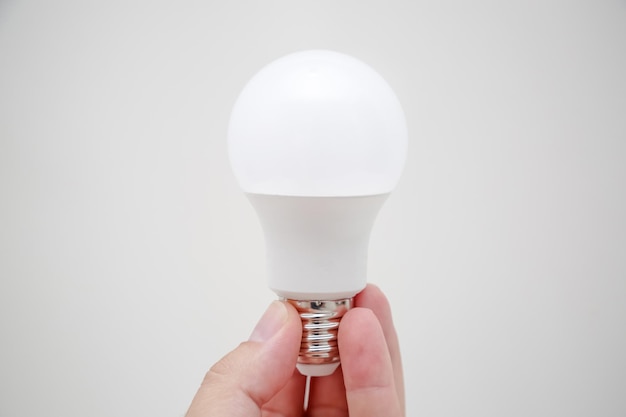 Ampoule LED blanche dans la main à économie d'énergie