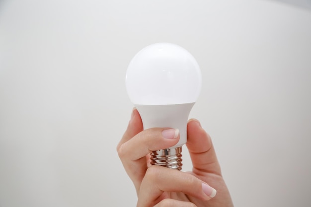 Ampoule LED blanche dans la main à économie d'énergie