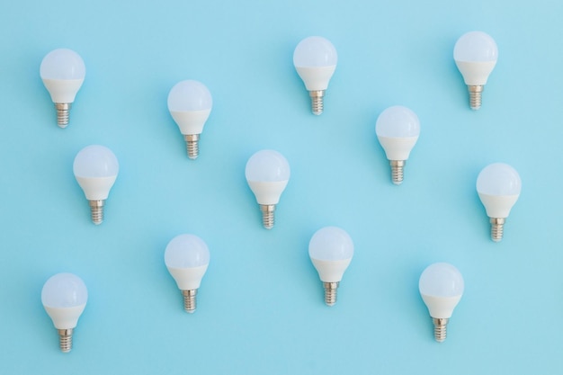 L'ampoule LED se trouve sur un fond bleu pastel Concept d'économie d'énergie Vue de dessus du minimalisme