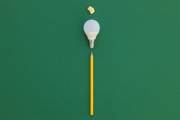 L'ampoule LED se trouve sur un fond vert pastel Concept d'économie d'énergie Vue de dessus du minimalisme