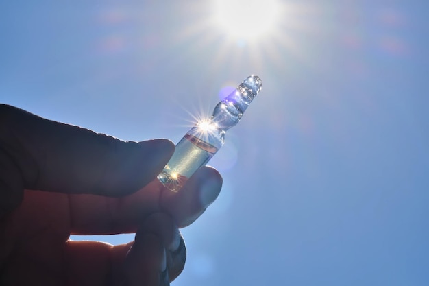 Ampoule à la main contre le ciel bleu