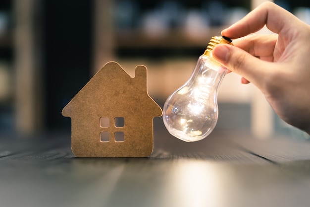 Ampoule avec maison en bois sur la table