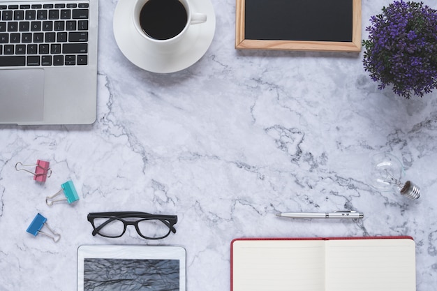 ampoule et outils de bureau sur fond de marbre blanc