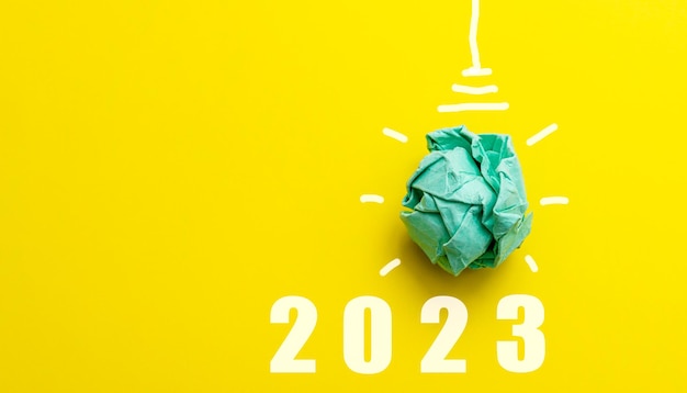 Ampoule en papier vert 2023 vision du nouvel an et concept innovant de résolution d39entreprise énergies renouvelables et durables