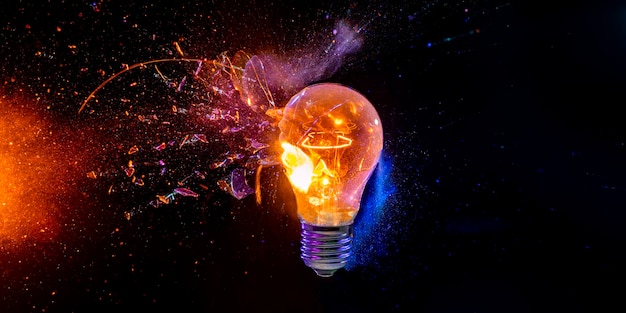 l'ampoule se brise et crée de nombreux fragments sur fond noir