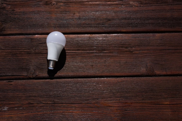 Une ampoule se trouve sur une table en bois