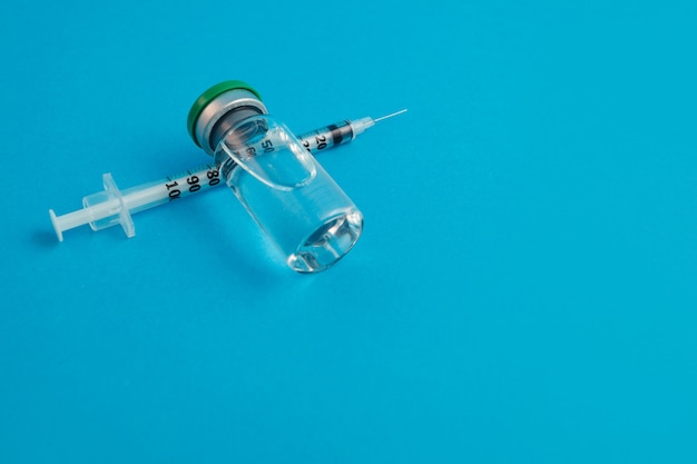 Photo ampoule seringue avec médicament sur fond bleu