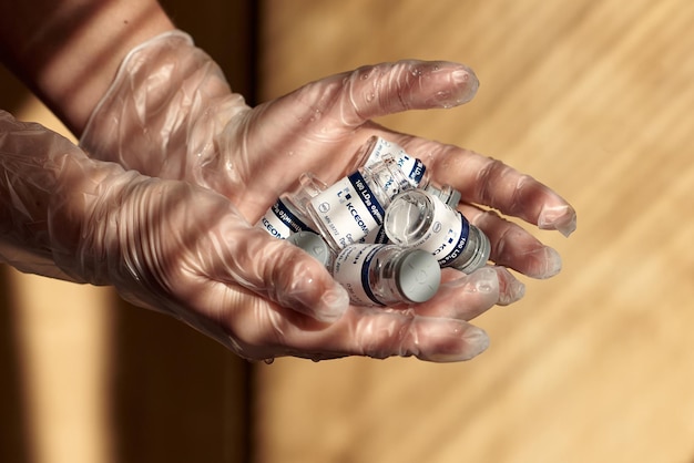 Ampoules de correction du visage sur les mains d'une femme dans les rayons de lumière