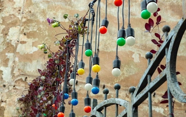 Ampoules d'éclairage de couleur décorative au-dessus des portes de jardin en fer entre les maisons