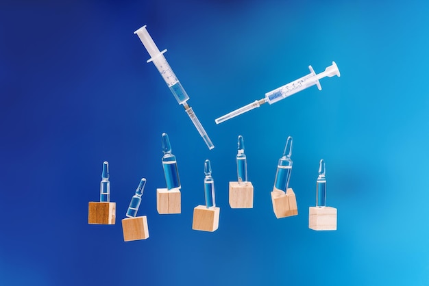 Ampoules médicales sur fond bleu avec vaccin médecine collagène vitamines liquide clair