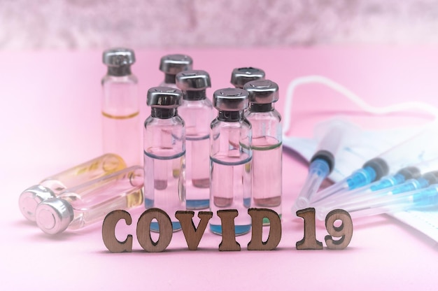 Photo ampoules médicales, seringues et masque sur fond vert vaccination contre le covid-19