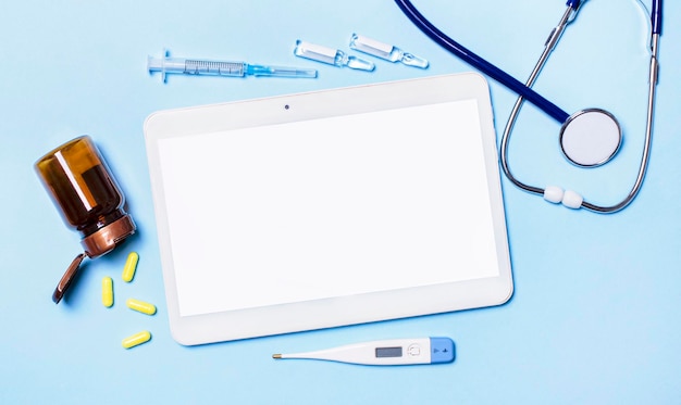 Photo ampoules pilules un stéthoscope un thermomètre une tablette avec un endroit pour insérer du texte sur la table du médecin diagnostic médical ou maquette de prescription médicale concept de médecine