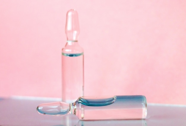 Ampoules pour produits médicaux et cosmétiques sur fond rose Solution de substance pour injection