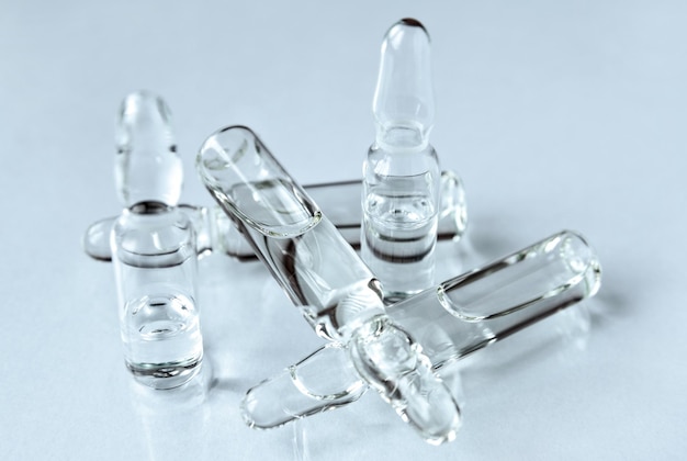 Ampoules en verre avec médicament injectable sur fond clair