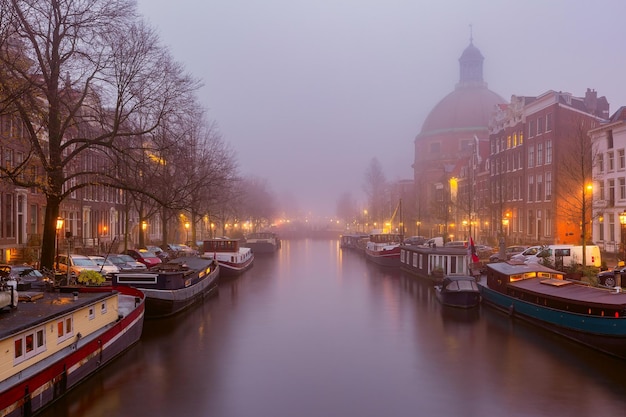 Photo amsterdam canal singel avec des maisons typiques néerlandaises pendant l'heure bleue du matin hollande pays-bas