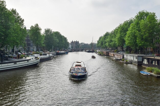 AMSTERDAM, PAYS-BAS, 01 JUIN 2016 : Vue de l'un des canaux et des bateaux avec un vieux bâtiment en arrière-plan à Amsterdam, Pays-Bas Eon 01 juin 2016.