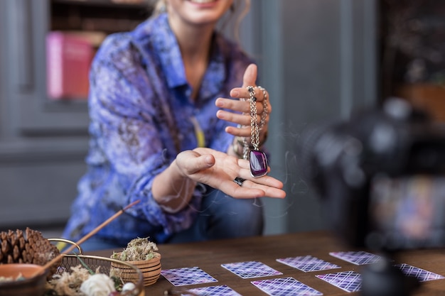 Amulette spéciale. Gros plan d'un beau joli collier tout en étant entre les mains des femmes