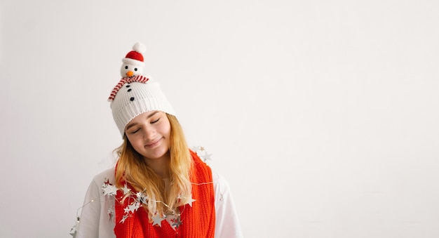 Amusante jeune fille dans un chapeau de Noël avec un bonhomme de neige et une écharpe rouge Nouvel An et concept de Noël