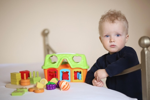 Amusement de l'enfance et concept de personnes heureux petit garçon derrière la porte à la maison