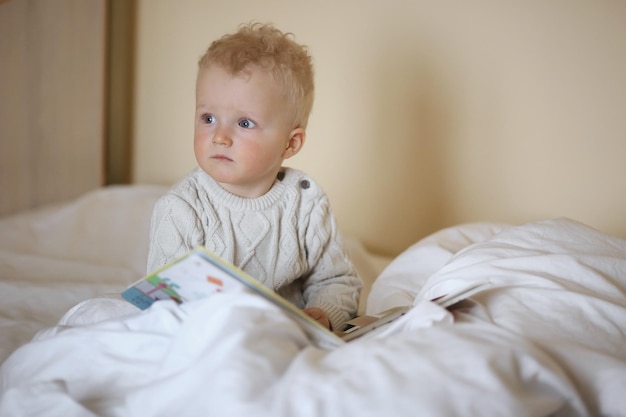 Amusement de l'enfance et concept de personnes heureux petit garçon derrière la porte à la maison