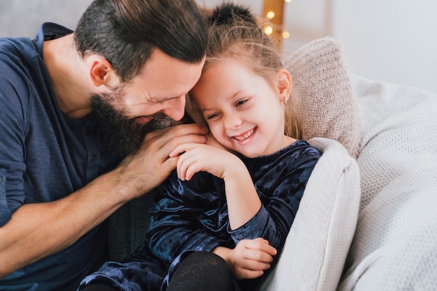 Amusement familial à la maison. Père aimant faisant des blagues, sa jolie petite fille en riant.