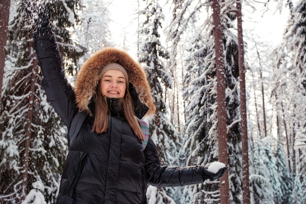 Amusement d'hiver dehors une jeune femme gaie joue des boules de neige