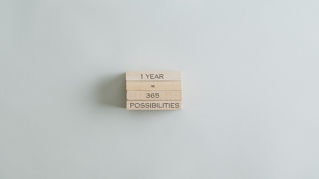 Un an, c'est 365 possibilités de signer sur une pile de chevilles en bois. Sur table beige