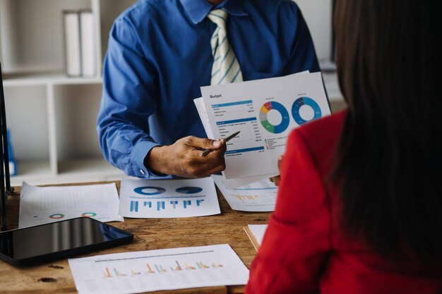 Photo les analystes financiers analysent les rapports financiers des entreprises sur un projet d'investissement de planification de tablette numérique lors d'une discussion lors d'une réunion d'entreprise montrant les résultats de leur travail d'équipe réussi