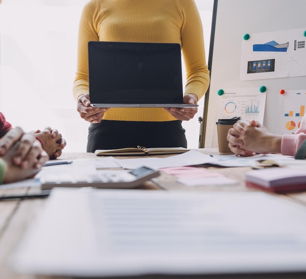 Les analystes financiers analysent les rapports financiers des entreprises sur un projet d'investissement de planification de tablette numérique lors d'une discussion lors d'une réunion d'entreprise montrant les résultats de leur travail d'équipe réussi