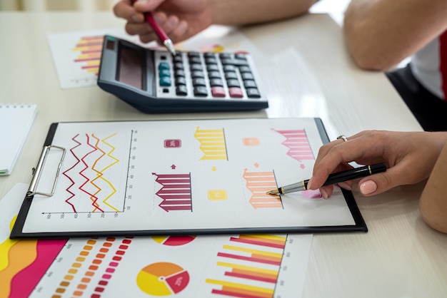 Analystes financiers travaillant avec des graphiques et des diagrammes. Mains humaines avec des stylos se bouchent