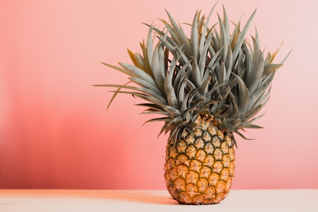 ananas avec de belles feuilles rares sur le plancher en bois pour le fond.