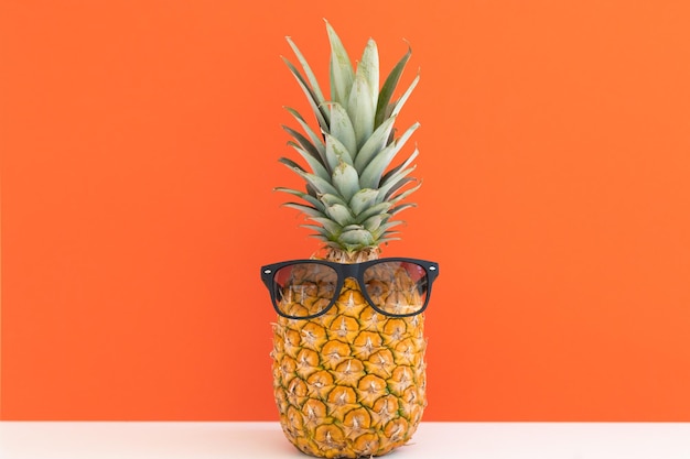 Ananas créatif avec des lunettes de soleil isolé sur fond de couleur plage de vacances d'été