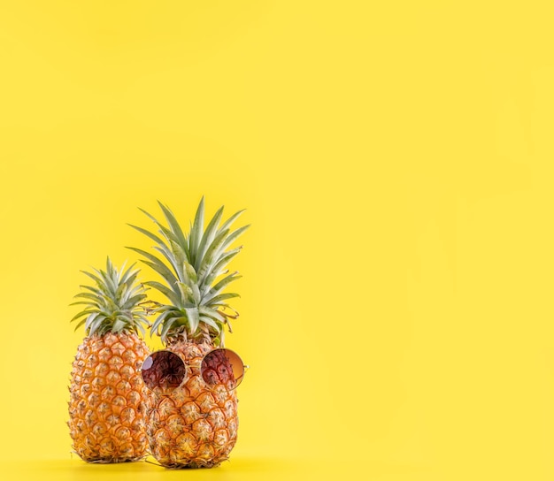 Ananas créatif avec des lunettes de soleil isolé sur fond jaune vacances d'été plage idée modèle de conception copie espace gros plan blanc pour le texte