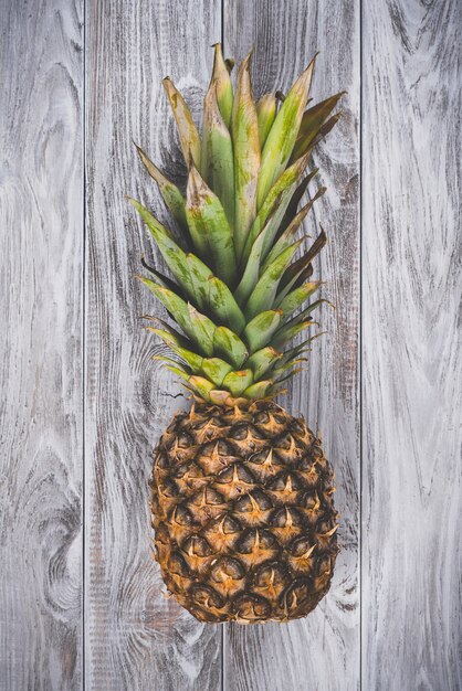 Un ananas cru sur la vue de dessus de la surface en bois blanc