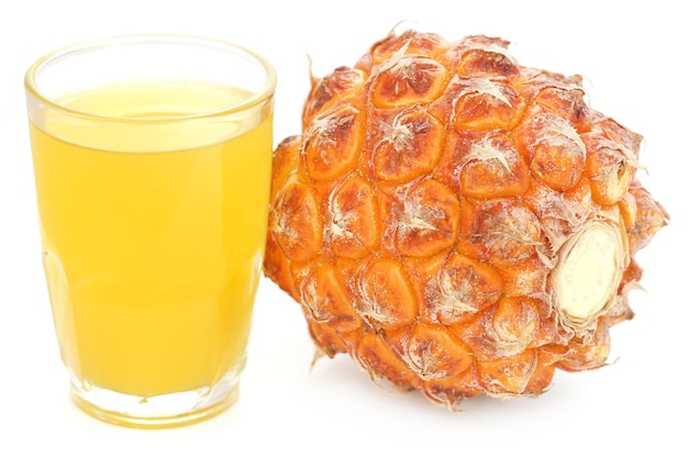 Ananas avec du jus dans un verre sur fond blanc